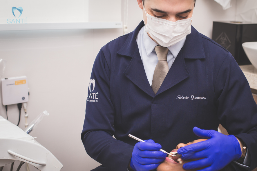 Dentista da Clínica Santé em Belo Horizonte realiza tratamento especializado para conter a perda óssea dentária em paciente no consultório.